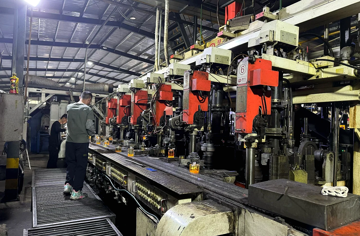 Glass bottle factory production line with workers and equipment