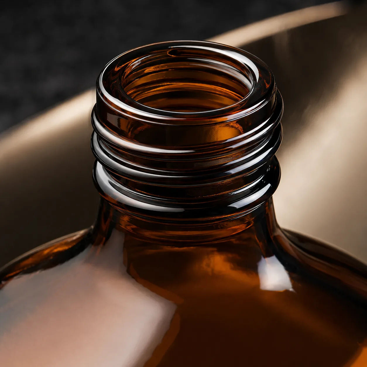 Close view of Amber Glass Flask Beverage Bottle showing closure area and print / coat / label