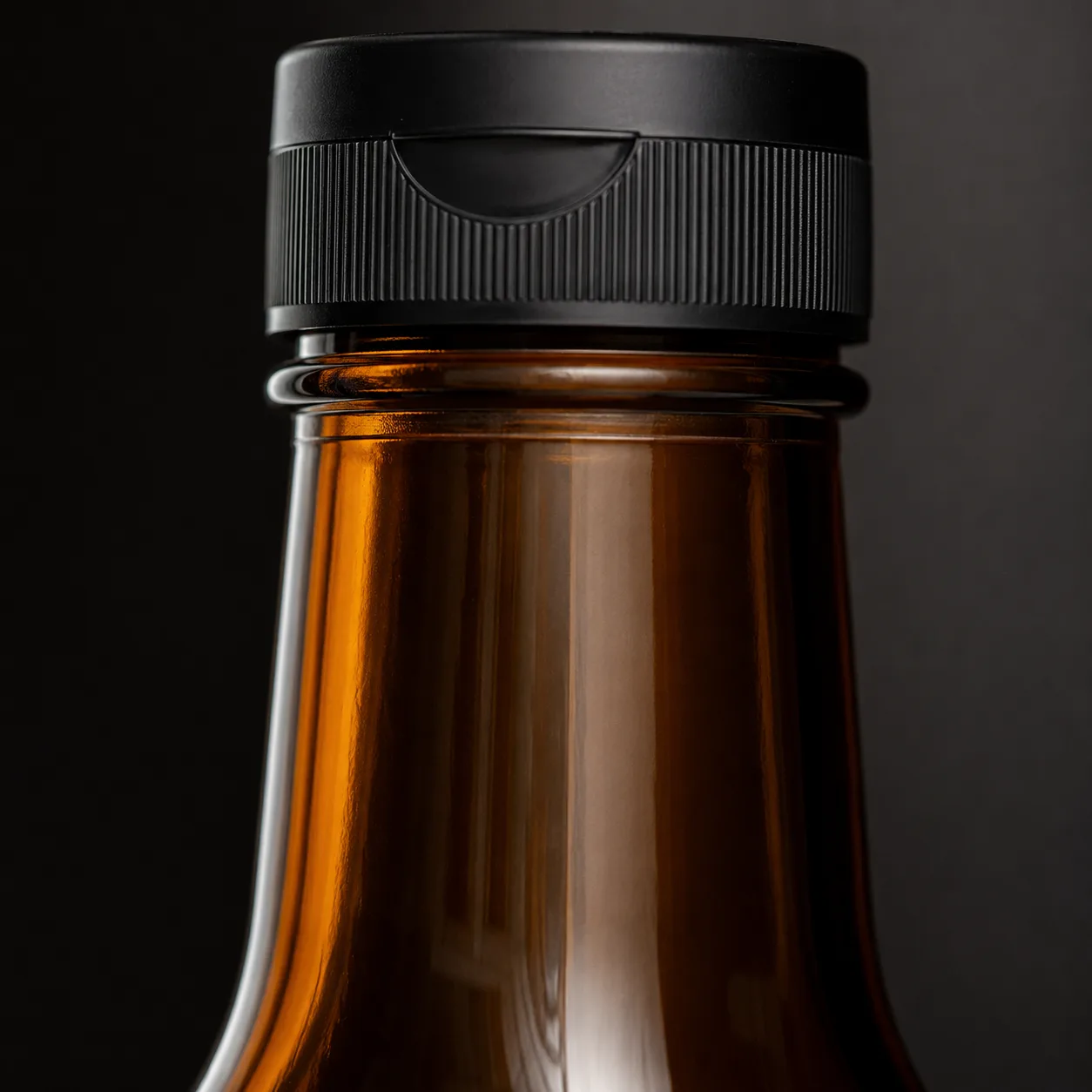 Close view of Amber Glass Sauce Bottle showing label area and print / coat / label