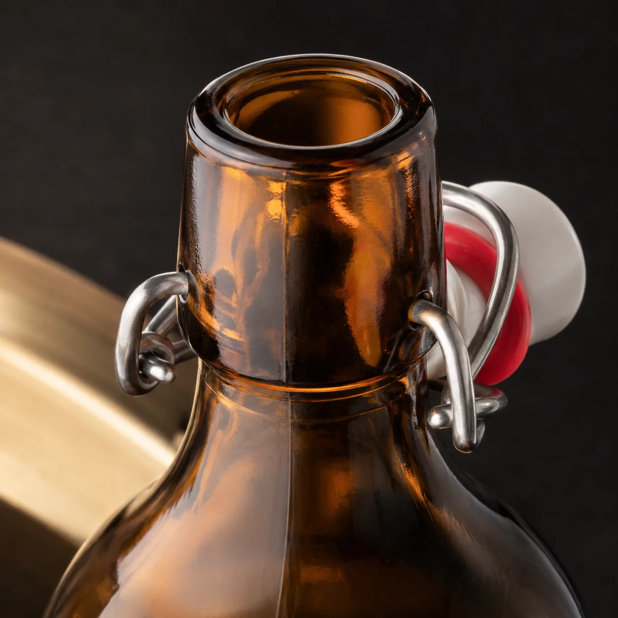 Close view of Amber Glass Swing-Top Beverage Bottle showing closure area and print / coat / label