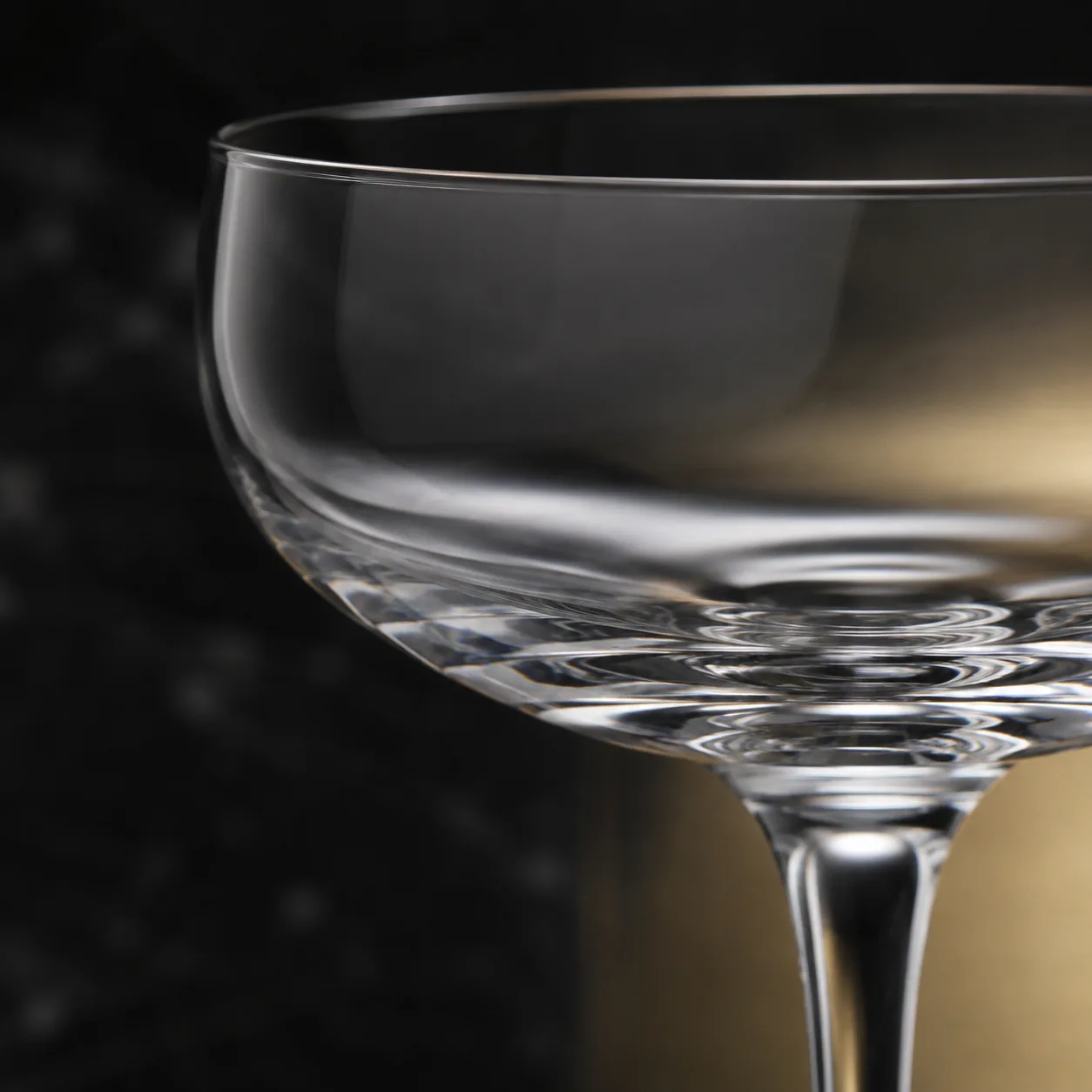 Close view of Champagne Coupe Glass showing stem or base and logo print / decal